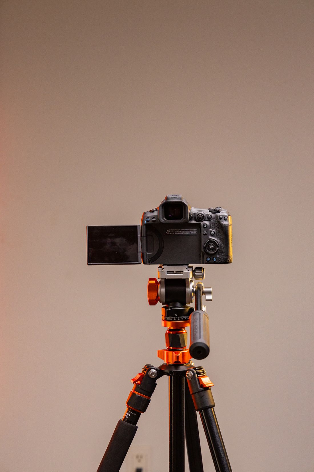 A professional camera mounted on a tripod in a studio.